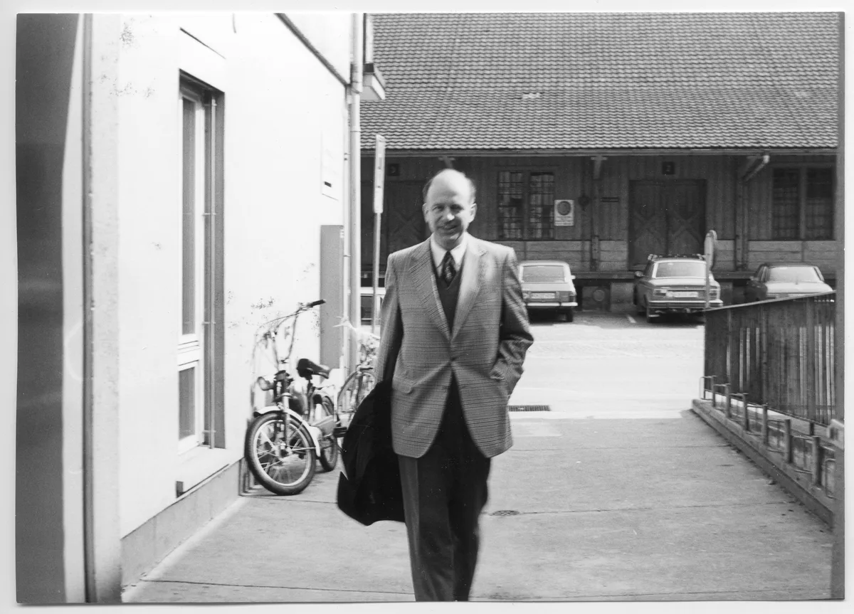 Schwarzweissfoto von Mann mit Anzug, der auf Kamera zugeht